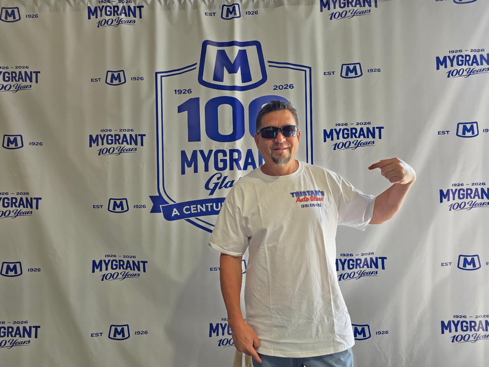 Tristan, owner of Tristan's Auto Glass, in his branded shirt