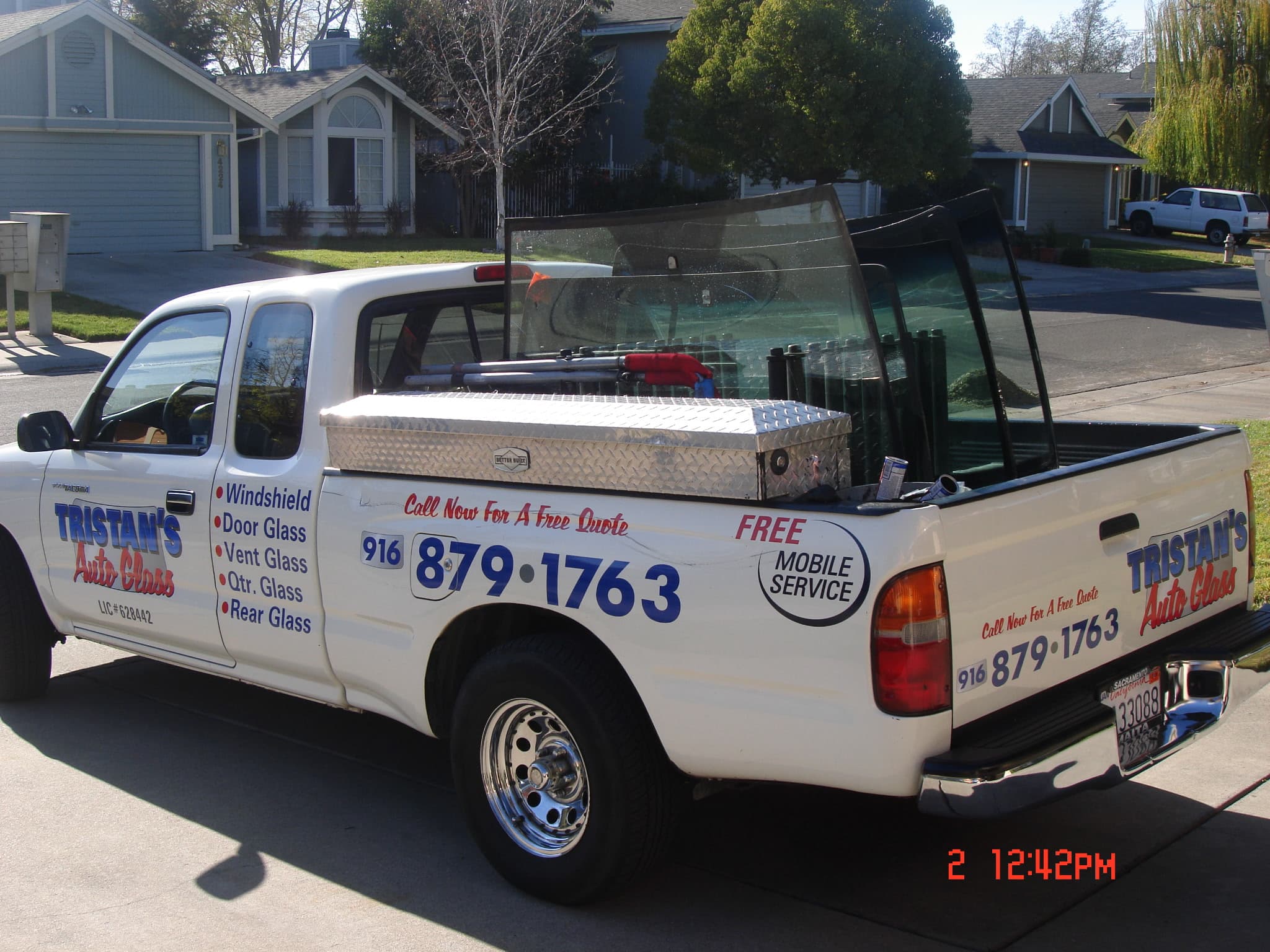 Tristan's Auto Glass branded service truck with phone number and services listed on the driver side